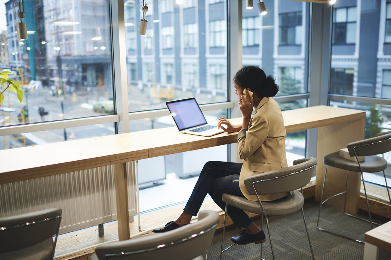 566815396-woman-on-laptop-and-mobile-city-cafe online aged care courses
